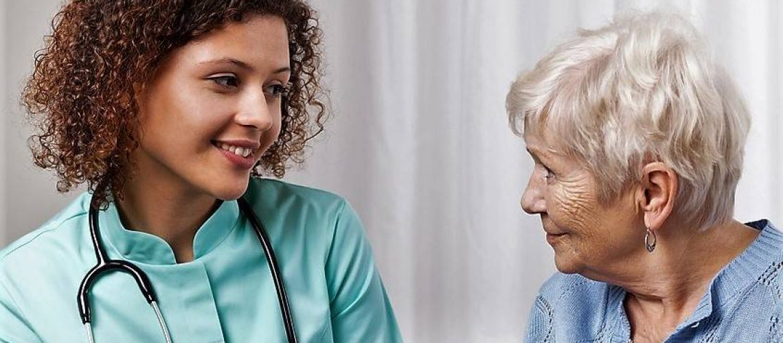Pretty nurse during conversation with elderly patient